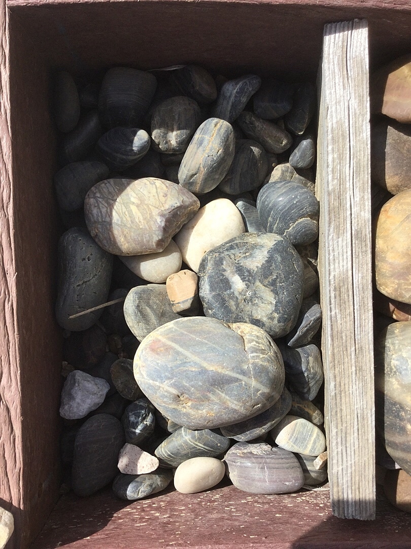 Smooth river rocks in wooden planter box